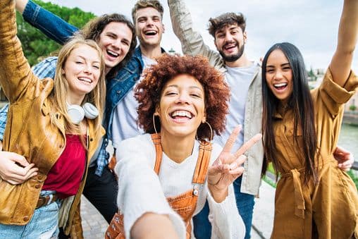 Grupo diverso de jovens felizes celebrando juntos
